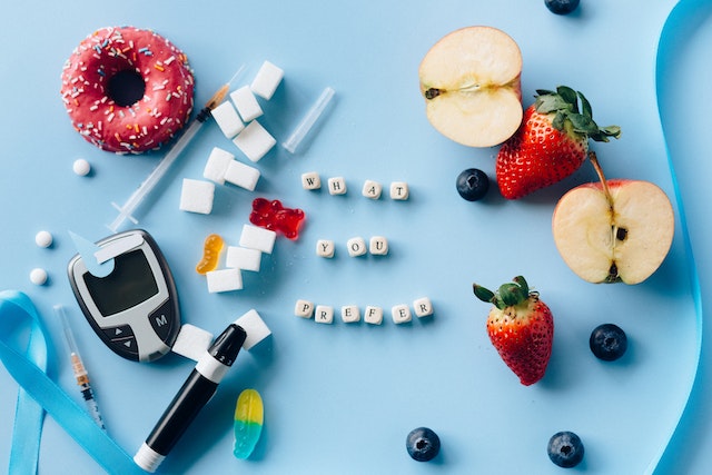 letter-dices-between-fresh-fruits-and-diabetes-equipment-on-a-blue-surface